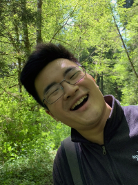 Ying looking happy and surprised with redwood trees in the background.